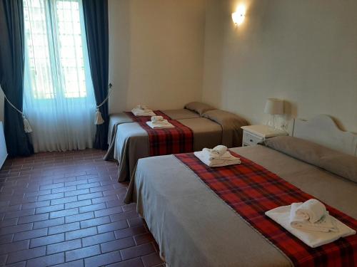 a hotel room with two beds with towels on them at Agriturismo Il Frantoio Di Colle Alberto in Montale