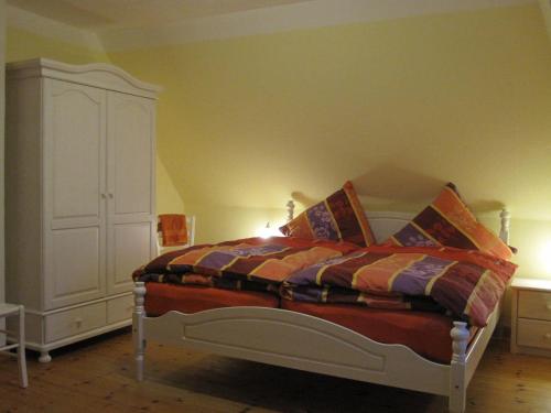ein Schlafzimmer mit einem Bett und einem weißen Schrank in der Unterkunft Schleisicht in Winnemark