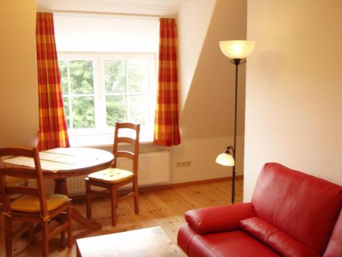 Una sala de estar con un sofá rojo y una mesa. en Schleisicht, en Winnemark