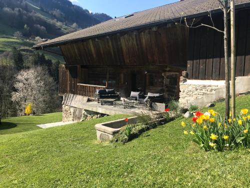 a house on a hill with flowers in front of it at Le 30 in Troistorrents