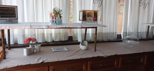 a table with vases and flowers on top of it at Hotel Vitorio in Cudillero