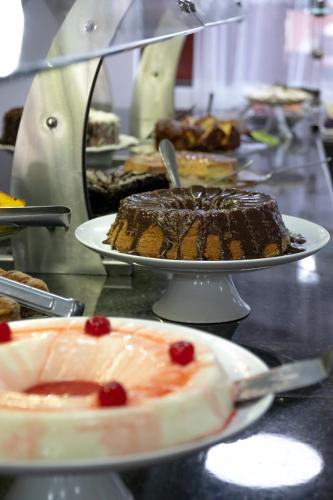 a bunch of desserts on plates on a table at Hotel Marazul in Cananéia