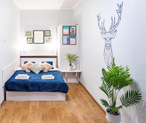 リヴィウにあるIn the center, comfort like at homeのベッドルーム1室(青いベッド1台、植物付)