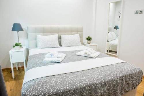 ein weißes Schlafzimmer mit 2 Handtüchern auf dem Bett in der Unterkunft Α26 Pristine & modern flat near Monastiraki square in Athens in Athen
