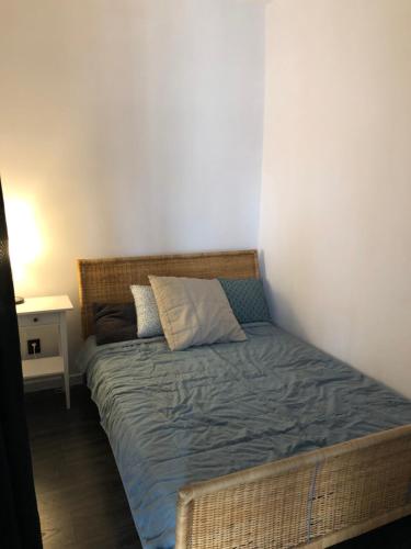 uma pequena cama num quarto com uma parede branca em Apartament Kościuszki em Malbork