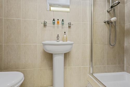a bathroom with a sink and a shower and a toilet at D19 SANGHA HALL in Leicester
