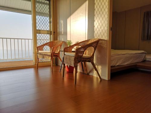 a room with two chairs and a table and a bed at 歐森View包棟Villa x 雲海夜景 x 獨立空間 in Dongshi