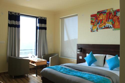 Habitación de hotel con 2 camas, escritorio y ventana en Shalom Backpackers Dharamkot McLeodganj, en McLeod Ganj