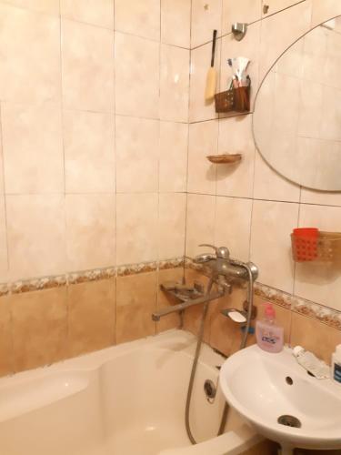 La salle de bains est pourvue d'une baignoire et d'un lavabo. dans l'établissement Очень уютная, тихая, єко комната с видом на сад, à Vinnytsia
