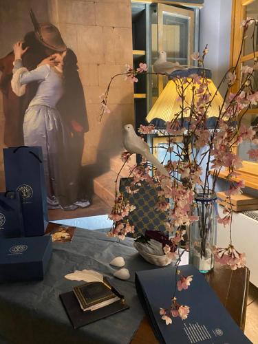 a table with a table cloth with flowers and a painting at Sotto il cielo di Toscana appartamenti in tenuta only adults no pet in Camaiore