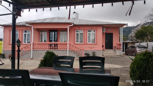 a pink house with a table and chairs in front of it at Kemeni Gardens in Batumi