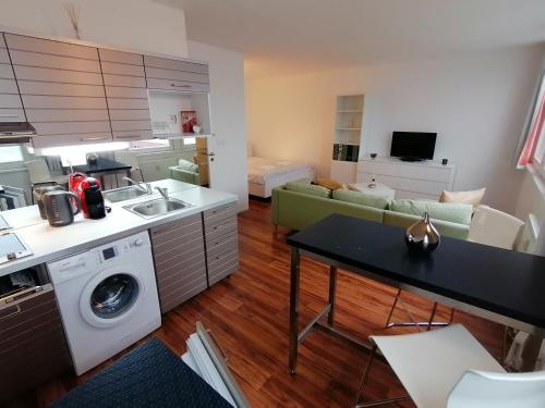 شقق غولدن فاميلي في براغ: مطبخ وغرفة معيشة مع أريكة وطاولة