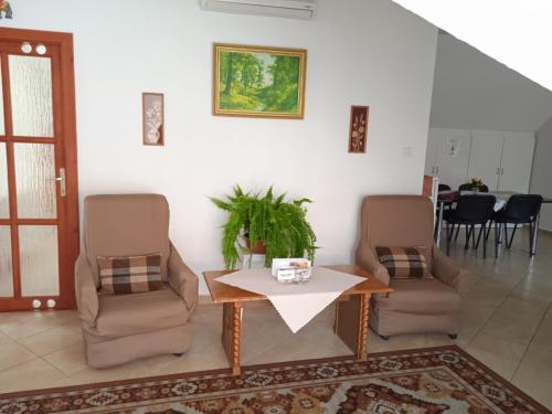 a living room with two chairs and a table at Agria Wellness Guesthouse in Eger