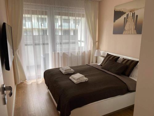 ein Schlafzimmer mit einem großen Bett mit zwei Handtüchern darauf in der Unterkunft Apartament Vento Bliżej Morza in Kołobrzeg
