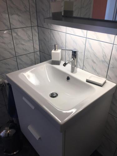lavabo blanco en el baño con espejo en Seewohnung Zentral en Millstatt