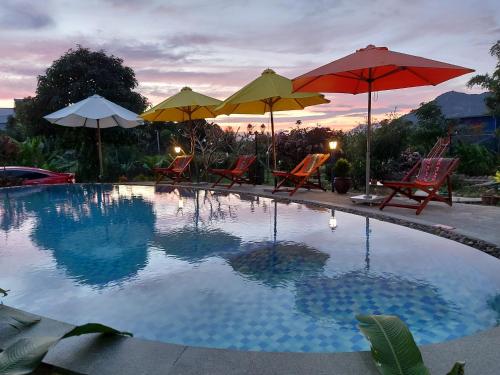 ein Pool mit Stühlen und Sonnenschirmen darüber in der Unterkunft Colours Land Home in Nha Trang