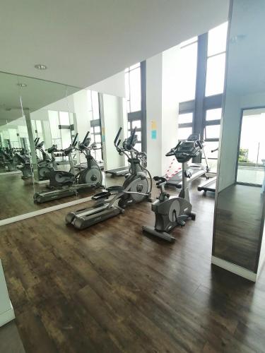a gym with several exercise bikes and a mirror at THE FAMILY HOMESTAY@UNIV360 PLACE,SERDANG in Seri Kembangan