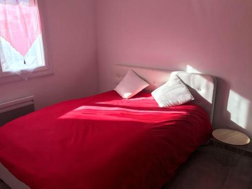 een slaapkamer met een rood bed en een raam bij appartement neuf P3 50m2 in Nîmes
