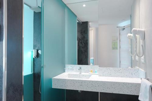 a bathroom with a sink, mirror, and bathtub at Hotel Benikaktus in Benidorm