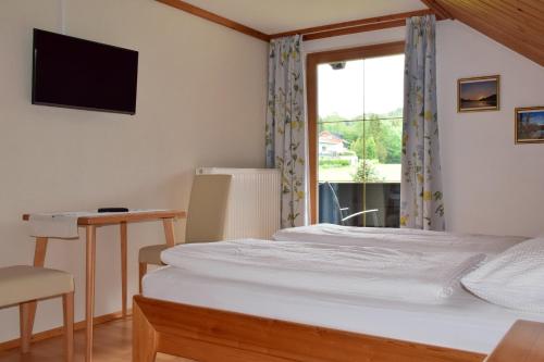 a hotel room with a bed and a window at Pension Hohenau in Fuschl am See