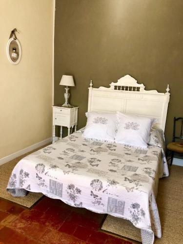 1 dormitorio con cama blanca y cabecero blanco en Le Sillon d'Alaric, en Lézignan-Corbières