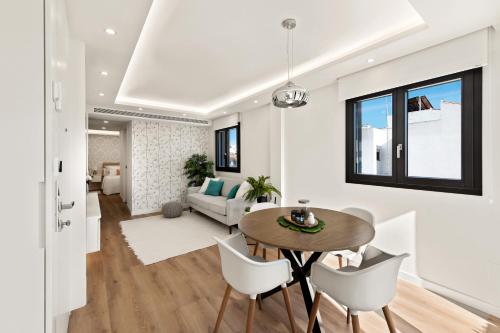 uma sala de jantar e sala de estar com mesa e cadeiras em Sunny modern Apartment Perfect located em Estepona