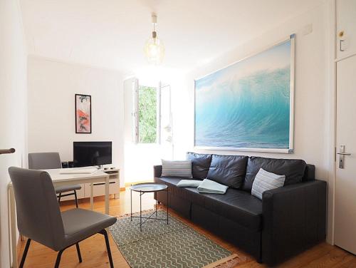 a living room with a black couch and a desk at Mosteiro - Lissabon Altstadt in Lisbon