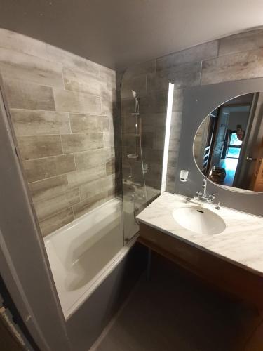 La salle de bains est pourvue d'un lavabo, d'une douche et d'un miroir. dans l'établissement Chamonix / Argentière - Duplex 6p, à Chamonix-Mont-Blanc