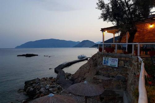 a building with umbrellas next to a body of water at Meltemi Appartment in Patitiri