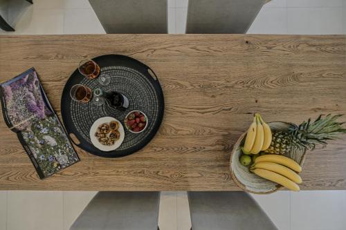 a table with a plate of food and fruit on it at Sea & Olives Suites Hotel and Villas in Plaka