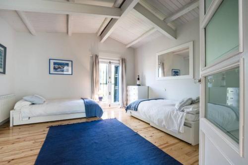 a bedroom with two beds and a blue rug at Preciosa Villa de Campo / Wonderful Country Villa in San Agustín de Guadalix