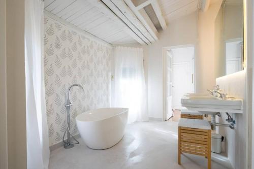 ein weißes Badezimmer mit einer Badewanne und einem Waschbecken in der Unterkunft Preciosa Villa de Campo / Wonderful Country Villa in San Agustín de Guadalix