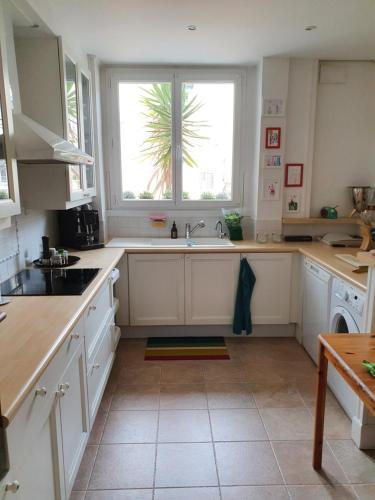 a white kitchen with a sink and a window at Appartement Centre ville carré d'Or in Monte Carlo