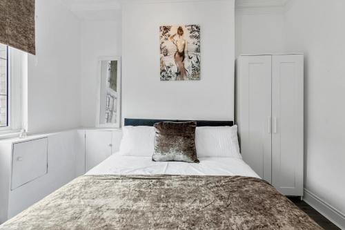 um quarto com uma cama com paredes brancas em Staywhenever TS- 4 Bedroom House, King Size Beds, Sleeps 9 em Stoke-on-Trent