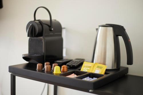a black tray with a tea kettle and packets at Modern Hideout Ace Location in Amsterdam