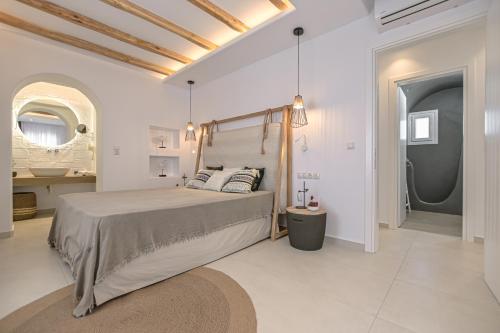 a bedroom with a large bed and a bathroom at Sea & Olives Suites Hotel and Villas in Plaka