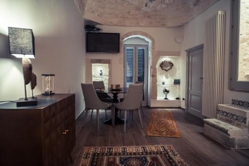 a living room with a dining room table and chairs at 800s Home Luxury Rooms in Ostuni