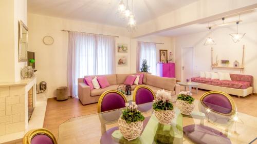 ein Wohnzimmer mit einem Sofa und einem Tisch in der Unterkunft Villazia Exclusive Estate in Episkopianá