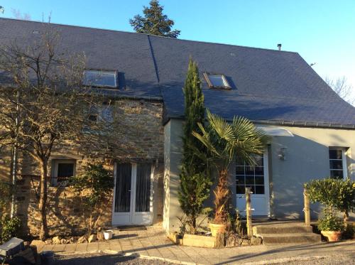 une maison blanche avec un palmier devant dans l'établissement L Entre deux, à Champcey