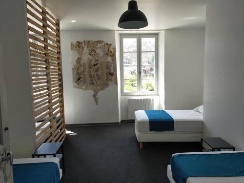 1 dormitorio con 2 camas y ventana en Gîte Les Pieds dans l'Olt - Ultreïa en Estaing