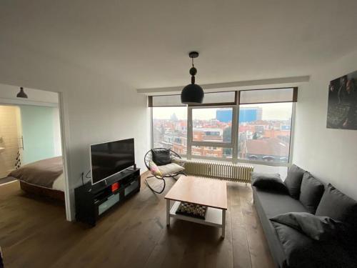 a living room with a couch and a large window at Brussels By Night panoramic studio apartment for 2 in Brussels