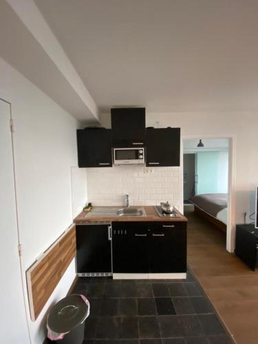 eine Küche mit Spüle und Mikrowelle im Zimmer in der Unterkunft Brussels By Night panoramic studio apartment for 2 in Brüssel
