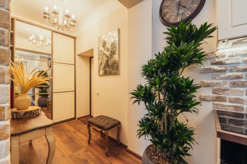 a hallway with plants and a clock on the wall at Rezidence Liepas in Liepāja
