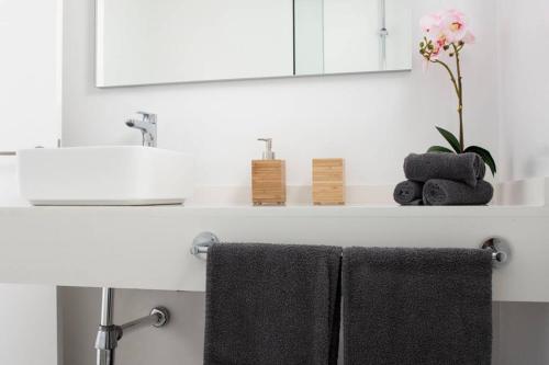 umywalkę z 2 ręcznikami i lustrem w obiekcie Apartamento Aguaviva, tu lugar al lado del Océano w Costa Teguise