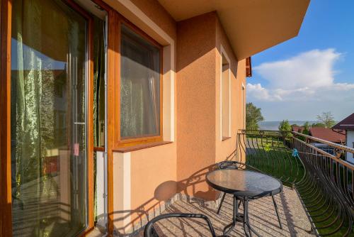 balkon ze stołem i krzesłami oraz oknem w obiekcie APARTAMENT JAN-53 Krynica Morska w mieście Krynica Morska