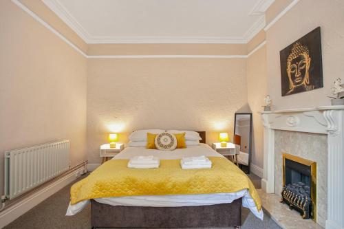 a bedroom with a king sized bed and a fireplace at Staywhenever NWT- 4 Bedroom House, King Size Beds, Sleeps 9 in Stoke on Trent