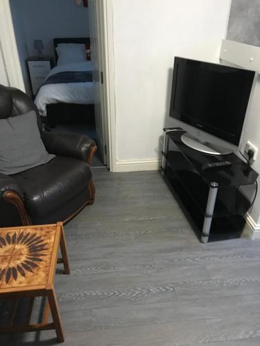 a living room with a television and a couch at 2 bedroom apartment in Plymouth