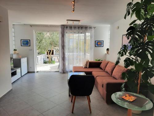 a living room with a couch and a potted plant at Apartment Mato in Barbariga