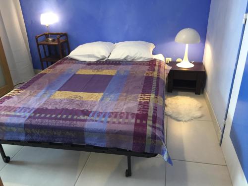 Plagne 1800にあるAppartement rez de jardin et garage privéのベッドルーム(紫色の掛け布団付きのベッド1台付)