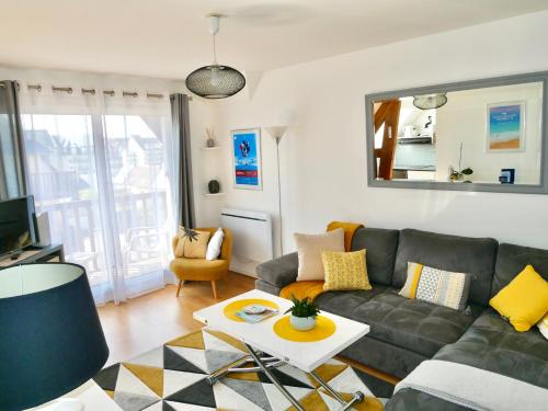 ein Wohnzimmer mit Sofa und Tisch in der Unterkunft Cabourg Mathilde in Cabourg